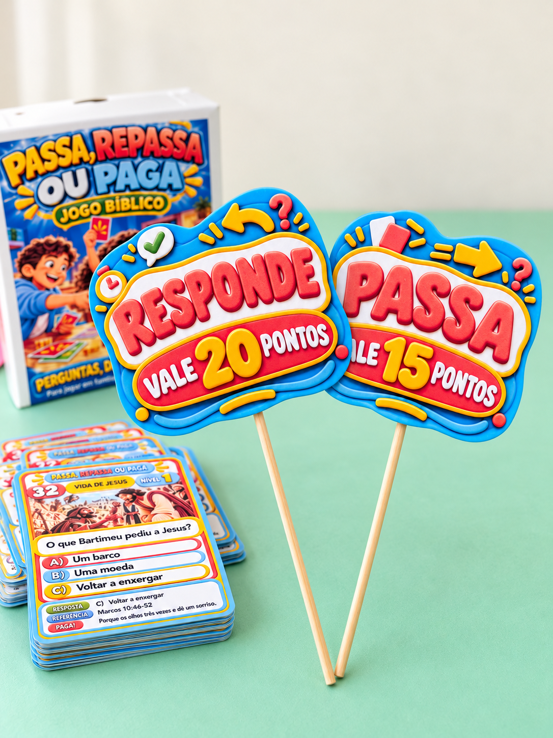 Plaquinhas Responde e Passa em pé ao lado de uma pilha de cartas e da caixa do jogo